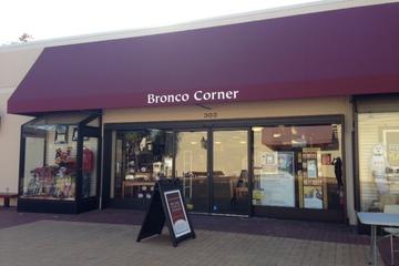 A storefront with Bronco Corner under a maroon awning.