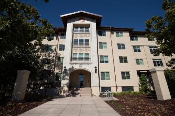 Four-story building with arched entrance, labeled Finn Residence Hall.
