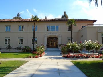 Exterior of a two-story building labeled Walsh Administration. Pathway and landscaped area in front.
