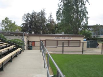 Concession stand at Stevens Stadium with surrounding greenery and bleachers in the foreground.